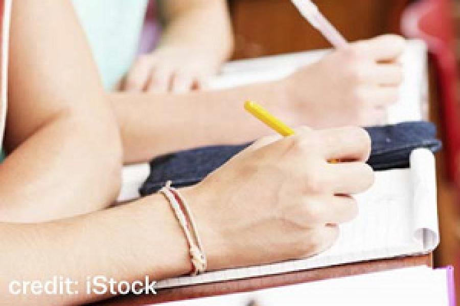 Closeup of hands writing at a desk